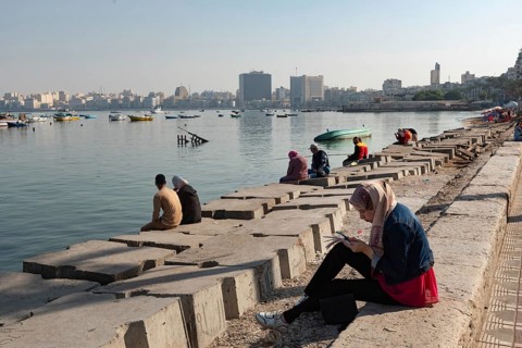 Alexandria, Egypt. December 1st 2022 People on concrete blocks positioned as a defence against