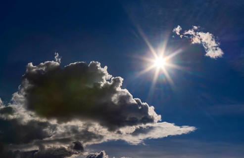 Sun shines between cumulus clouds, dramatic cloudy sky, Austria