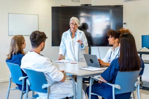 Experienced doctor explaining a new treatment to her colleagues during a medical training, using a
