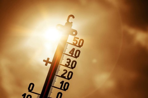 Thermometer in front of bright sun shows high temperatures, symbolic photo heat wave, photo montage
