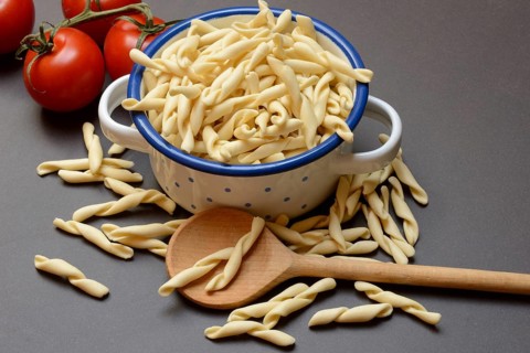 Uncooked strozzapreti, Italian type of pasta in pot