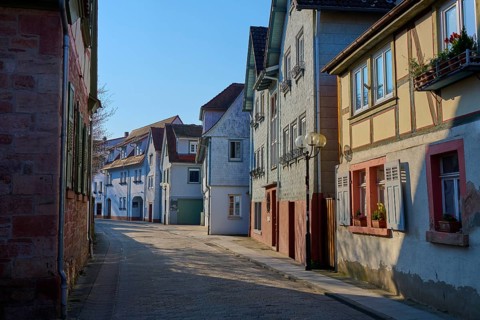 Sunny alley with half-timbered houses that exude a peaceful village atmosphere, Am Schlossgraben,