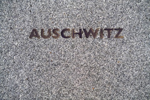 Floor plate with the inscription German concentration camp, death camp AUSCHWITZ in front of the