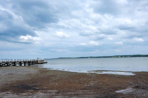 A long jetty juts into the sea while clouds gather over the sky, Hohwacht, Schleswig-Holstein,