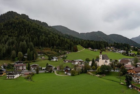 Drone shot, view of village with parish church, Waidring, Pillerseetal, Tyrol, Austria