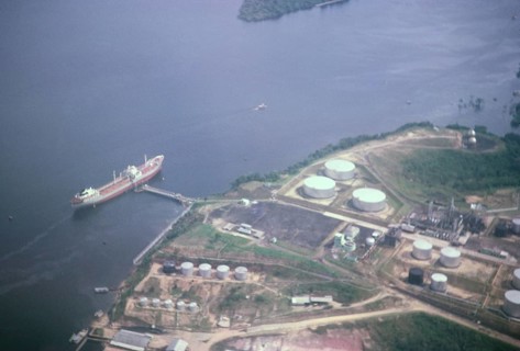 Aerial view of a large oil tanker docked at the jetty of a terminal, Manaus, Brazil 1962