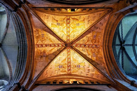 Gothic vault with ornately decorated frescoes under warm light, Saint-Paul-Aurélien Cathedral in