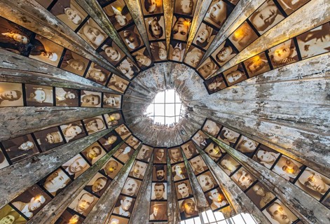 An upward look inside the concrete bunker dome lined with portraits of victims of the communist