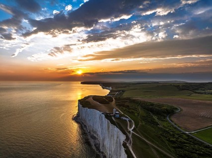 Sunset over Belle Tout Lighthouse from a drone, English Channel, Beachy Head Cliffs, East Sussex,