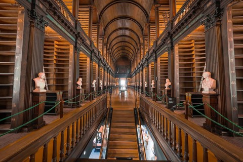 Symmetrical library with wooden galleries and classic busts, Trinity Collage, Dublin, Ireland