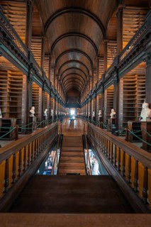 Historic library with busts and wooden interior in symmetrical arrangement, Trinity Collage,