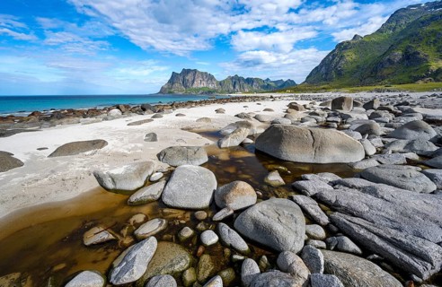 Coast and mountains, stones on the sandy beach of Uttakleiv, Vestvågøya, Lofoten, Nordland, Norway