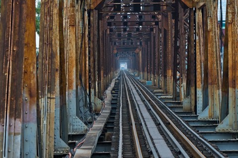 A Vietnamese State Railroad train crosses the Long Bien Railway Bridge across the Red River, Hanoi,