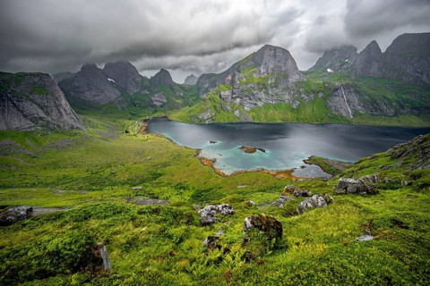 View over Kjerkfjorden fjord, mountain peaks and dramatic clouds, climb to Helvetestinden summit,