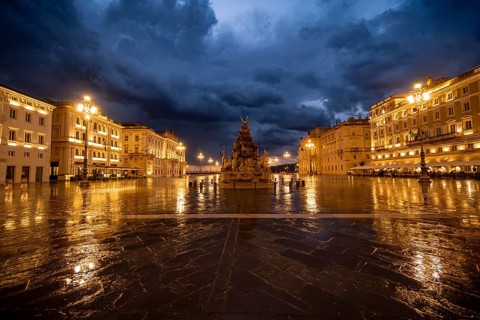 Illuminated square Piazza Unità d'Italia with Fontana dei Quattro Continenti fountain, Palazzo del