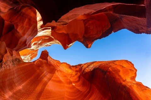 Swirling sandstone formations inside a famous slot canyon creating a natural frame for the bright