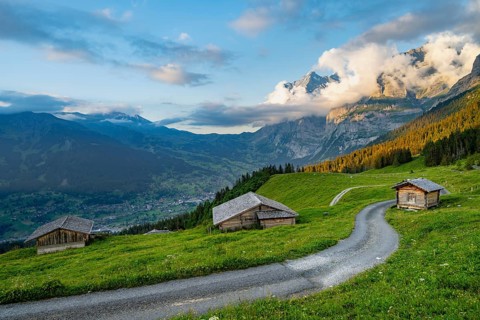 Road, alpine huts and alpine meadows, sunset, summit of the Wetterhorn in the back, Alpiglen,