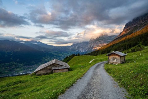 Road, alpine huts and alpine meadows, mountain landscape at sunset, summit of the Wetterhorn in the