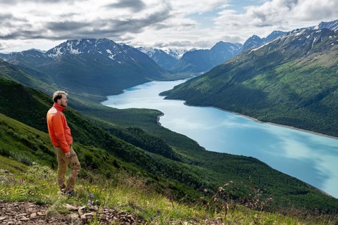 Mountaineer enjoys views of blue lake and mountains on Twin Peaks Trail, Eklutna Lake, Chugach