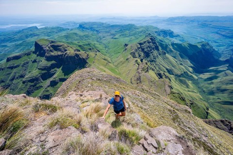 Female mountaineer hiking trail to Cathedral Peak or Cathedralpiek or Mponjwana, Drakensberg,