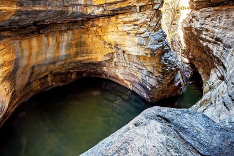 A bay-like formation with calm water surrounded by tall, winding rocks, deep gorge in the spiny