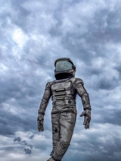 Antalya, Turkiye - 25.10.2025: An astronaut in a space suit stands against a cloudy sky. The scene