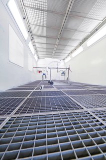 Industrial painting booth with mesh floor and equipment in bright surroundings, Painter, Calw,