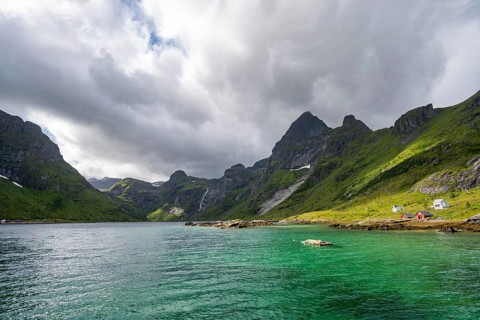 Waterfall and fjord landscape with mountains, Reinefjord, Lofoten, Norway