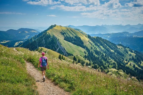 Active senior woman hiking along the picturesque ridge of the Nagelfluh Mountains in the Allgäu