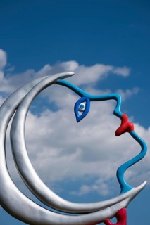 Face in front of a cloudy sky, part of a sculpture, Giardino dei Tarocchi or Garden of Tarot, by