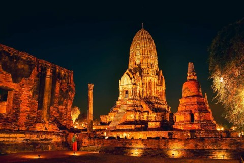 Visitor taking picture Wat Ratchaburana ancient temple in Ayutthaya. Illuminated central prang