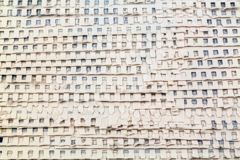 Close-up of overlapping ripped and torn out white perforated pages background from spiral bound