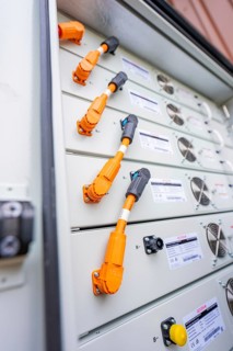 Detailed view of a control cabinet with orange connectors, Goodwe battery energy storage on a farm,