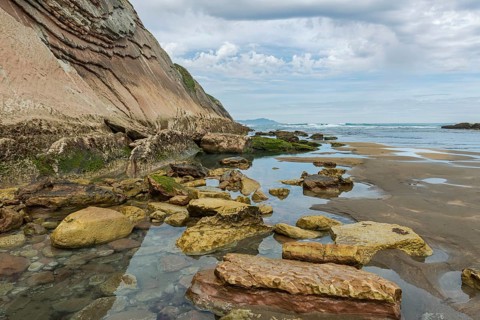 Distinctive rock cliffs as a geological formation of rock layers, Flysch on Itzurun Beach in