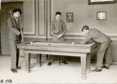 Young men, disabled, disabled, three men playing at a pool table in an elegant room with portraits