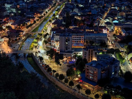 Night view of a city from above with illuminated river and busy streets, Prizren, Kosovo