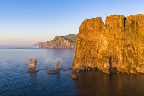 The Risin og Kellingin pinnacles off the Eysturoy cliffs in the evening light, Faroe Islands,