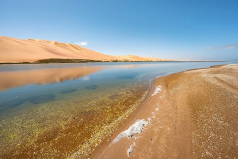 Sand dunes are reflected in Sandwich Harbour Lagoon, Impressive Desert Landscape, Namib Naukluft