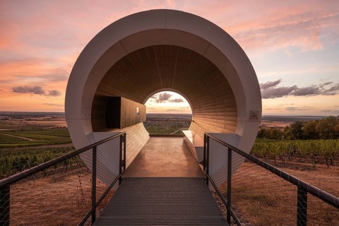 20 August 2026, View of the modern terroir f pavilion overlooking vineyard landscapes at sunset in