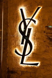 Vienna, Austria - 15 December, 2025: Illuminated YSL logo on a textured wall in Vienna, Austria.