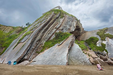Empty chairs in front of distinctive rock cliffs as a geological formation made of rock layers,