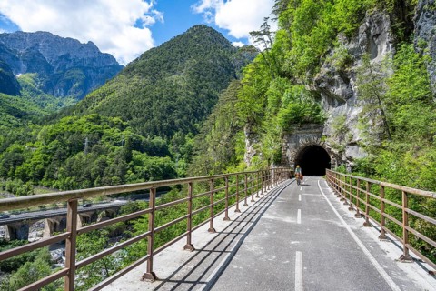 Cyclists with panniers on a cycle path with tunnel, cycle path along the old Pontebba railway line