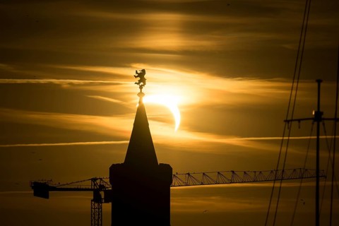 Shortly in front of sunset, the sun darkens during a solar eclipse, seen here with the Warsaw