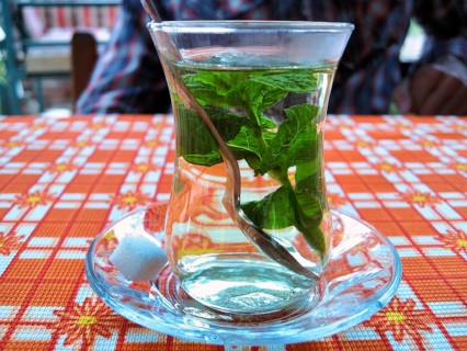 Fresh mint tea in a tea glass, traditionally prepared with fresh mint leaves, sugar cubes, oriental
