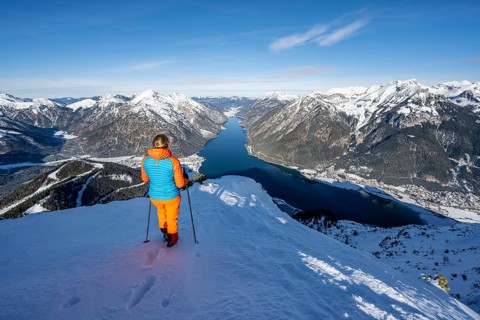 View of Achensee and wintry mountain scenery, ski tourer at the summit of Bärenkopf, Achensee,
