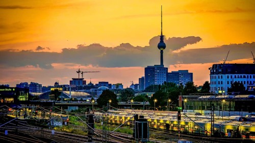 Sunset over train tracks and parked trains, Berlin with the distinctive television tower and urban