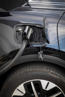 Fully electric Ford Explorer is being charged, charging cable in power tank, charging station for