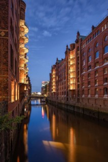 Historic brick warehouses are reflected in the calm water of the wall frame fleet of Hamburg's