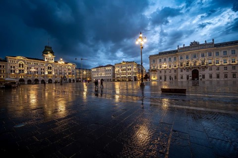 Illuminated square Piazza Unità d'Italia, City Hall, Palazzo Communale and Palazzo del Lloyd