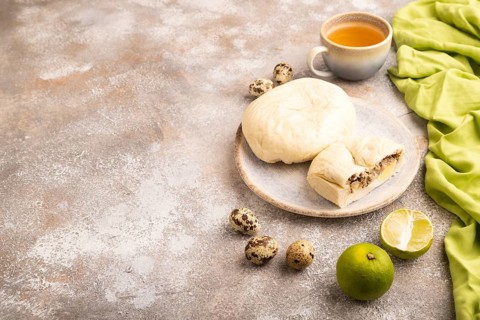 Vietnamese steamed buns Banh bao on brown concrete background and green linen textile. side view,